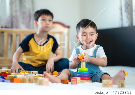 Brother and a smile boy play a toy togather Brother and a smile boy play a toy togather 47528315