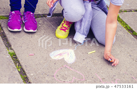 Children draw the heart on the asphalt. Children draw the heart on the asphalt. 47533161