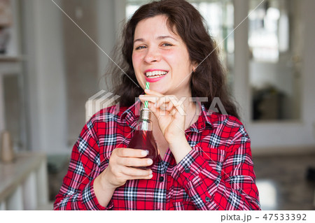 Diet, healthy lifestyle and detox concept - young woman with cherry juice in bottle looks like a Diet, healthy lifestyle and detox concept - young woman with cherry juice in bottle looks like a 47533392