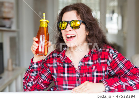 Detox, diet and healthy lifestyle concept - young woman holds a bottle of fresh juice Detox, diet and healthy lifestyle concept - young woman holds a bottle of fresh juice 47533394