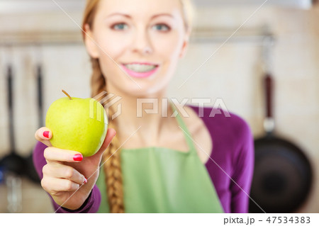 Woman young housewife in kitchen with apple fruit 47534383