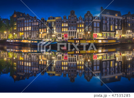 Cityscape of Amsterdam at night with reflection of buildings on water 47535285