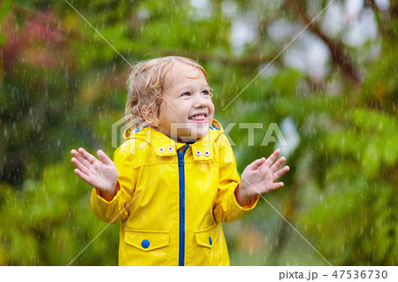 Kids play in autumn rain. Child on rainy day. 47536730