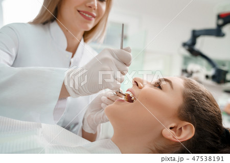 Female patient lying on dental chair with open mouth Female patient lying on dental chair with open mouth 47538191
