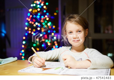 Inspired little girl at the table draw with crayons or do home work 47541483