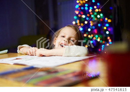 Inspired little girl at the table draw with crayons or do home work Inspired little girl at the table draw with crayons or do home work 47541615