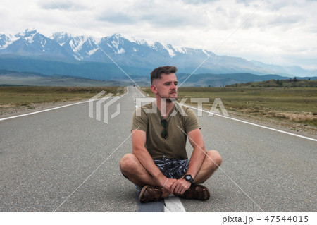 Man sitting on the road 47544015