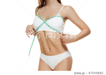 Portrait of beautiful young woman measuring her lfigure size with tape measure. Portrait of beautiful young woman measuring her lfigure size with tape measure. 47544692