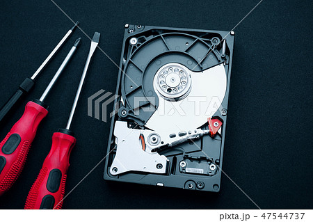 Uncovered hard disk drive and screwdrivers 47544737
