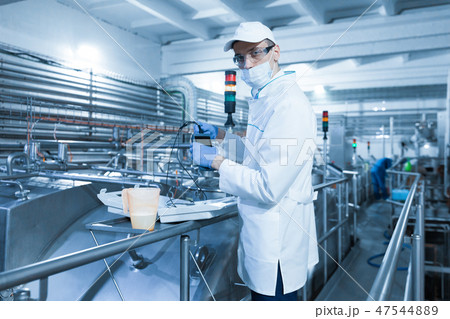 man in a mask and a Bathrobe connects the dosimeter to the dairy Plant 47544889