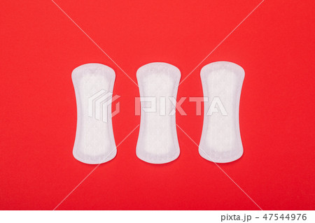 Three female sanitary pads isolated on red background Three female sanitary pads isolated on red background 47544976