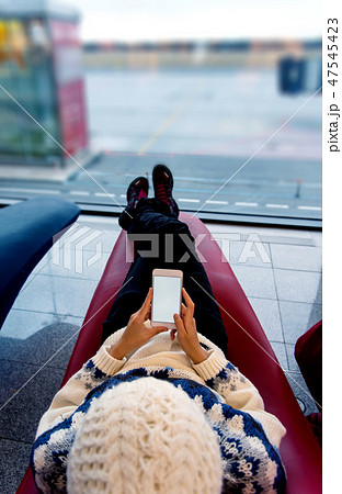 Girl using phone while waiting at the airport 47545423