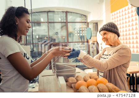 Cheerful poor woman being thankful for the soup Cheerful poor woman being thankful for the soup 47547128