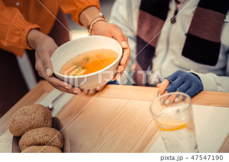 Bowl of tasty hot soup in female hands 47547190