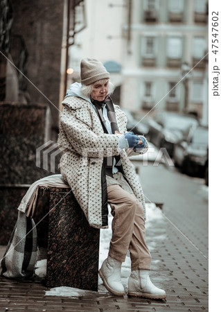 Depressed cheerless woman eating on the street 47547602