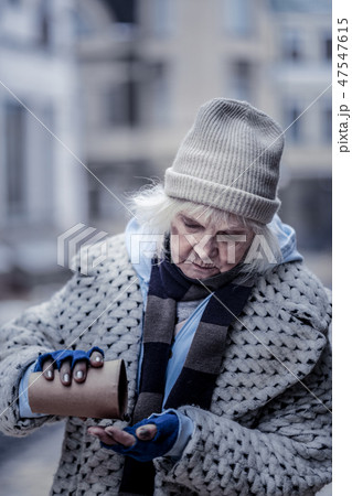 Sad unhappy aged woman checking her money 47547615