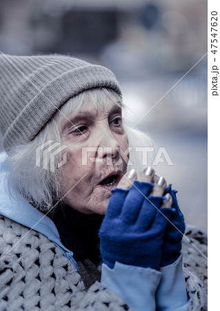 Depressed aged woman breathing at her hands 47547620