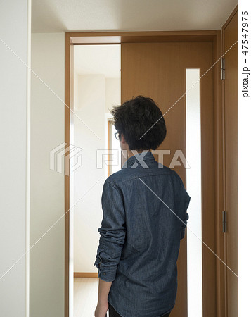 室内ドアを開ける男性の写真素材