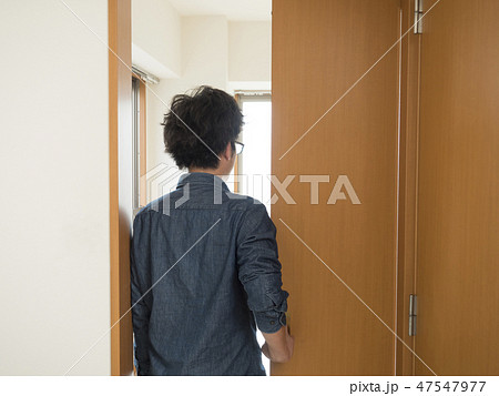 室内ドアを開ける男性の写真素材