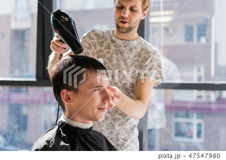 Drying, styling men's hair in a beauty salon 47547980