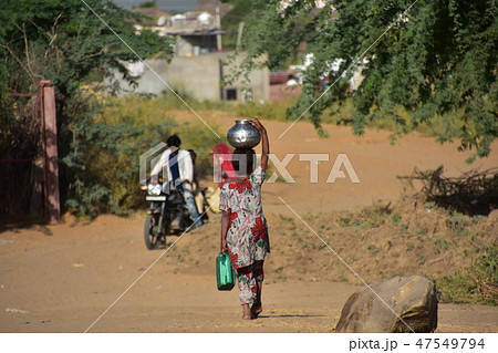 インドのラジャスタン州のプシュカル 砂漠で生活する子供 水瓶を頭に乗せて運ぶ少女 インドのラジャスタン州のプシュカル 砂漠で生活する子供 水瓶を頭に乗せて運ぶ少女 47549794