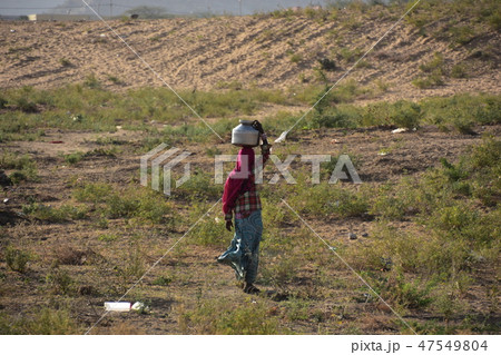 インドのラジャスタン州のプシュカル　砂漠で生活するインド人　頭の上に水瓶を乗せて運ぶインド人女性 47549804