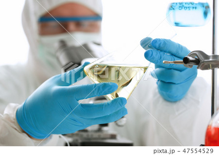 Male chemist look at microscope hold test tube 47554529
