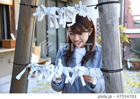 お参り　初詣　おみくじを結ぶ女性 47554703