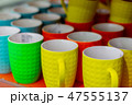 Many colored mugs in the store 47555137
