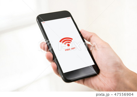 Male hand holding cellphone accessing free wifi 47556904