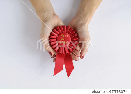 Woman holding a red 2nd place winners rosette Woman holding a red 2nd place winners rosette 47558074