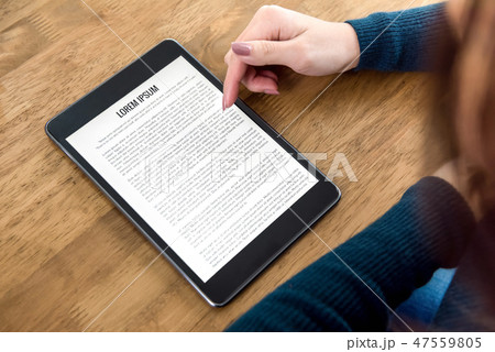 Student reading e-book reader at the table 47559805