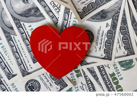 red heart and one hundred dollar money dollars with the image of Franklin scattered on the surface red heart and one hundred dollar money dollars with the image of Franklin scattered on the surface 47560002