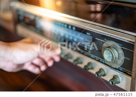 Male hand turning retro radio button Male hand turning retro radio button 47561115