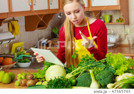 Woman in kitchen holding tablet 47565705