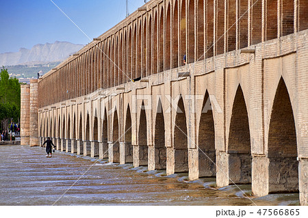 An Iranian man walks on water near bridge, Isfahan 47566865