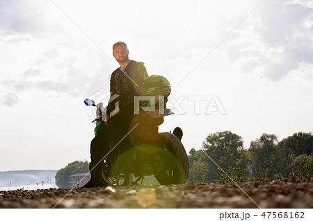 Biker man and motorcycle with river background, Rider moto trip on the street at the riverside Biker man and motorcycle with river background, Rider moto trip on the street at the riverside 47568162