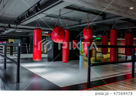 Red punching bags with gym background. Pears for boxing Red punching bags with gym background. Pears for boxing 47568478