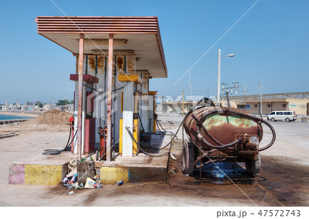 Rusty car tank stands near a small gas station. Rusty car tank stands near a small gas station. 47572743