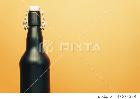 Black beer bottle on a old wooden table. Black beer bottle on a old wooden table. 47574544