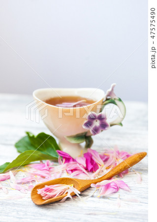 Cup of green tea and spring peonies blossom on a old wooden background. Rustic. 47575490