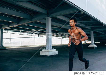 Bare chested sportsman running at bridge outdoors 47575968