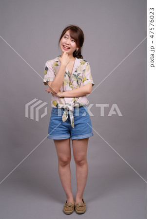 Full length portrait of beautiful young Asian woman standing 47576023