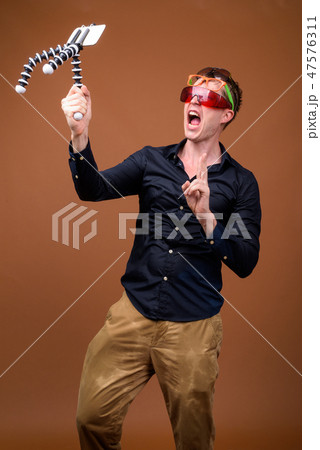 Young man influencer in wet clothes vlogging with mobile phone Young man influencer in wet clothes vlogging with mobile phone 47576311