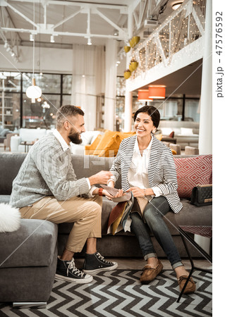 Laughing joyful couple choosing material for couch 47576592
