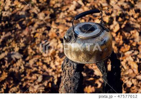 Tin tea kettle stands on spent swedish fire torch 47577012