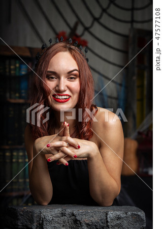 Beautiful young woman in black dress indoor 47577108