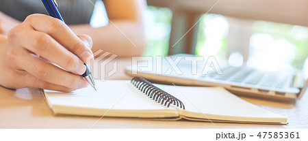 Woman hand is writing on notepad with pen. 47585361