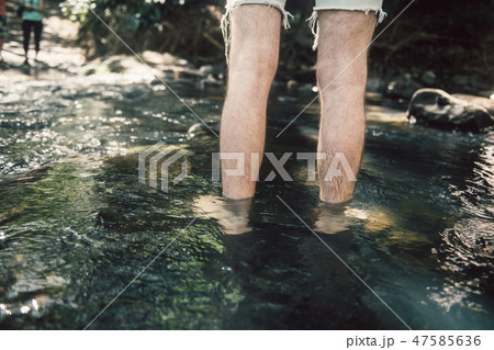 Man crossing the small mountain river bare feet Man crossing the small mountain river bare feet 47585636