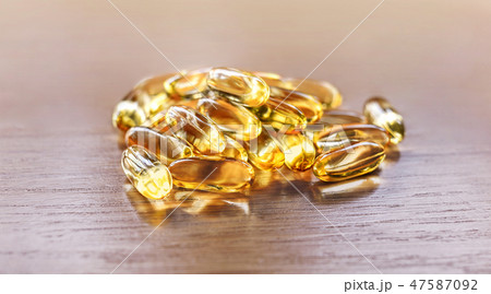 fish oil capsules on wooden table 47587092